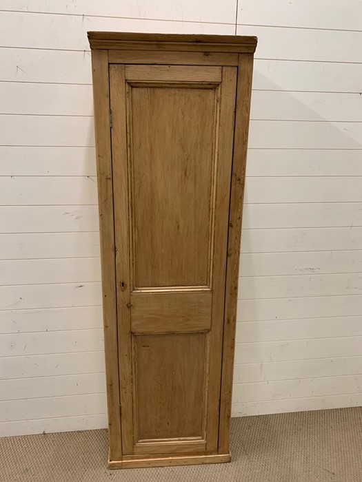 A tall pine hall cupboard opening to reveal shelves (H188cm W58cm D29cm)