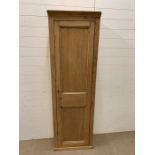 A tall pine hall cupboard opening to reveal shelves (H188cm W58cm D29cm)