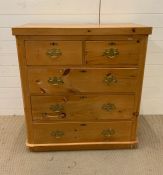 A pine two short over three long chest of drawers with brass handles (H103cm W97cm D46cm)