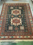 A dark green and red rug with four squares and two square design to center (270cm x 203cm)