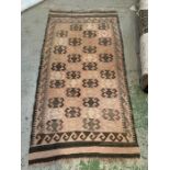 A brown and pink geometric design rug (183cm x 96cm)