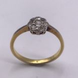 A Round Brilliant cut diamond centre, old cut diamond border daisy cluster ring. Center 2.7mm 0.07