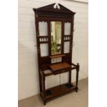 An oak hallstand with tiled back and a centre drawer (H209cm W93cm D33cm)