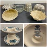 A selection of vintage jelly moulds and a Mason's china ham stand