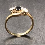 A 9ct gold ring with central sapphire and diamond shoulders.