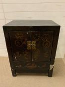 A Chinese black lacquer cabinet, doors decorated in gilt (H85cm W67cm D43cm)