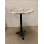 A cast iron table with marble top. (H71cm Dia50cm)