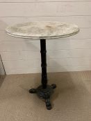 A cast iron table with marble top. (H71cm Dia50cm)