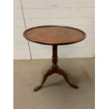 A walnut tilt top occasional table, with a dish top bird cage support and suppressed ball