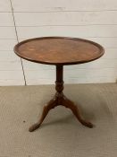 A walnut tilt top occasional table, with a dish top bird cage support and suppressed ball