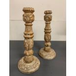 A pair of turned candle sticks with foliage decoration