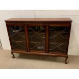 A mahogany display case with three glazed doors on ball and claw feet (H108cm W150cm D34cm)