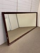 A large haberdashery shop mirror in a wooden frame (129cm x 294cm)