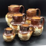 Six Royal Doulton Lambeth stoneware jugs, various sizes