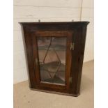 A Two Shelf Glazed corner cabinet with brass furniture H 84 cm x W 70 cm x D 34 cm