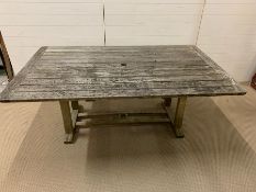 A large weathered wooden slatted garden table (W183cm D112cm)