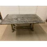 A large weathered wooden slatted garden table (W183cm D112cm)