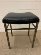 A Stool with black seat pad by Shaw tubular steel furniture.