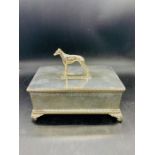 A silver plated cigar box surmounted by a cast Whippet dog and cedar wood lining interior, raised on