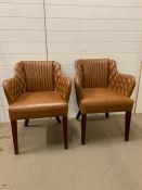 A Pair of Tan Leather padded leather armchairs