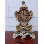 A Paris porcelain cased Rococo style mantel clock, with brass dial enclosing a two train movement
