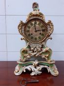 A Paris porcelain cased Rococo style mantel clock, with brass dial enclosing a two train movement