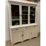 A painted oak dresser, with three glazed doors opening to shelves, the base has three drawers and