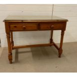 A pine desk with two drawers and a glass top