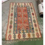 A cream, red and blue rug with a tree deign to center panel. (185cm x 117cm)