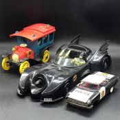 Three vintage toy cars to include a police car, batman car etc