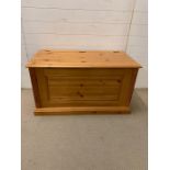 A pine blanket box with hinged lid (H58cm W103cm D53cm)