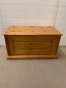 A pine blanket box with hinged lid (H58cm W103cm D53cm)