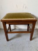 A mahogany stool with green upholstery