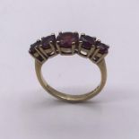 A 9 ct five stone ring, set with garnets (2.6g) Size K