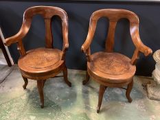 A pair of Italian barbers swivel chairs on four down swept legs and cross stretchers (H94cm W61cm)