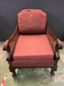 A Bergere chair with scrolled arms and ball claw feet.
