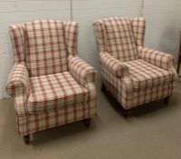 A pair of wing back arm chairs with red check upholstery