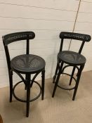 A pair of bar stools with cane back and seat