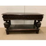 An oak carved hall or serving table with turned legs and drawers to centre (H77cm W129cm D46cm)