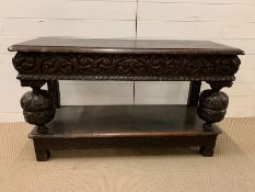 An oak carved hall or serving table with turned legs and drawers to centre (H77cm W129cm D46cm)