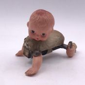 A vintage wind up mechanical crawling baby doll