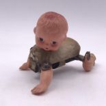 A vintage wind up mechanical crawling baby doll