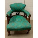 A mahogany upholstered library tub arm chair on turned legs ending in brass castors