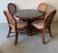 A cane and wicker dining table and four chairs (dia 106cm)
