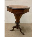 A antique walnut trumpet sewing table, inside is lined with original paper, standing on three carved