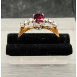 A 14 ct yellow gold ring with central ruby and three small diamonds to either side.