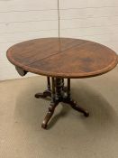 A dropped sided centre table on scrolled legs and four centre supports (H69cm W107cm D87cm)