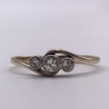 A Three stone diamond (0.2ct total) ring on an 18ct gold and platinum setting.