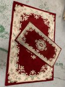 Two Indian red and cream rugs of different sizes