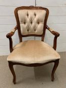 A mahogany style open armchair with buttoned back and upholstered seat